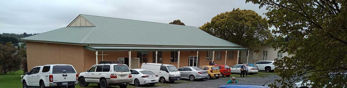 Church building with multiple cars parked in front of it